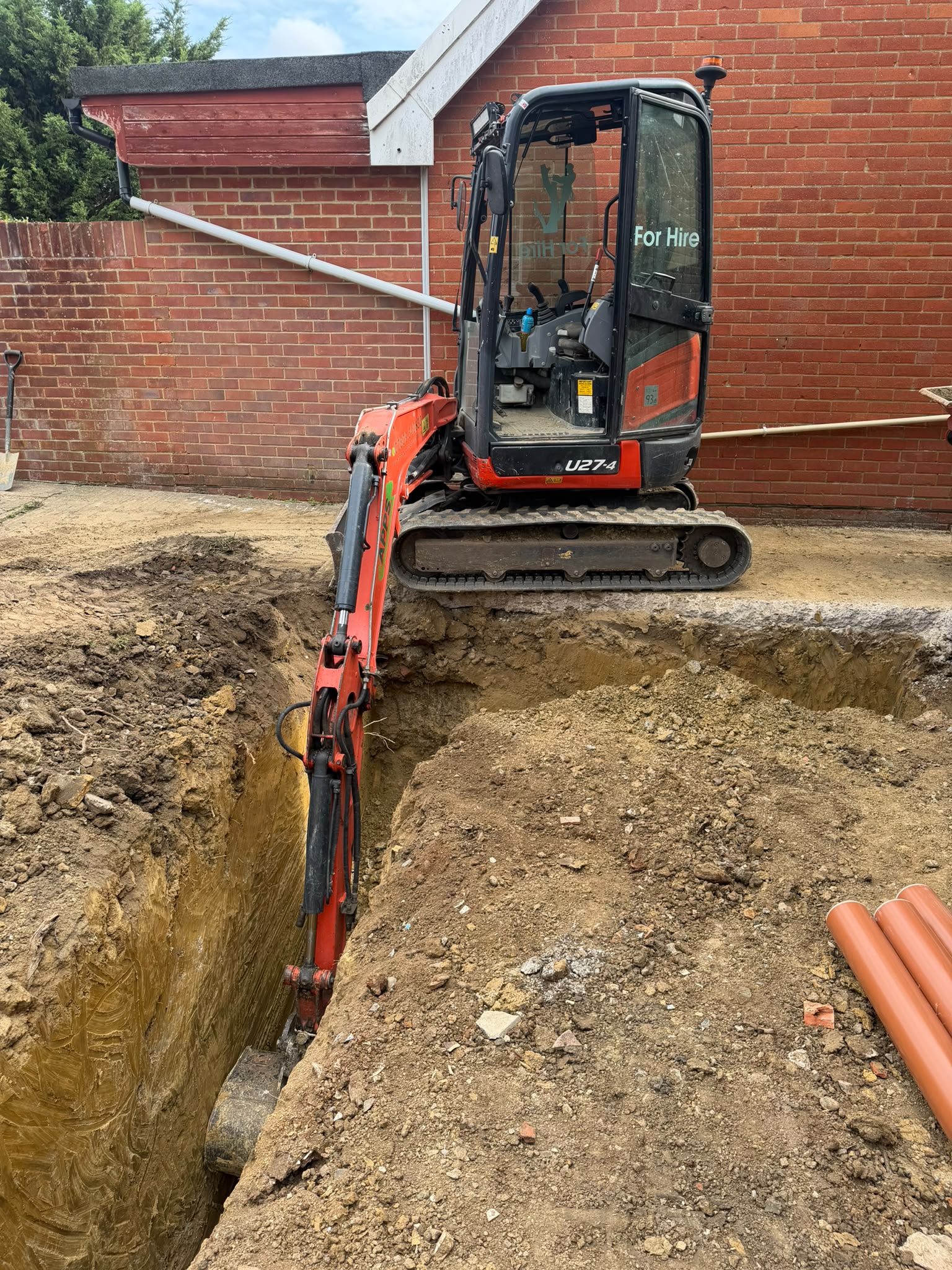 Mini digger undertaking groundwork excavation in Reigate
